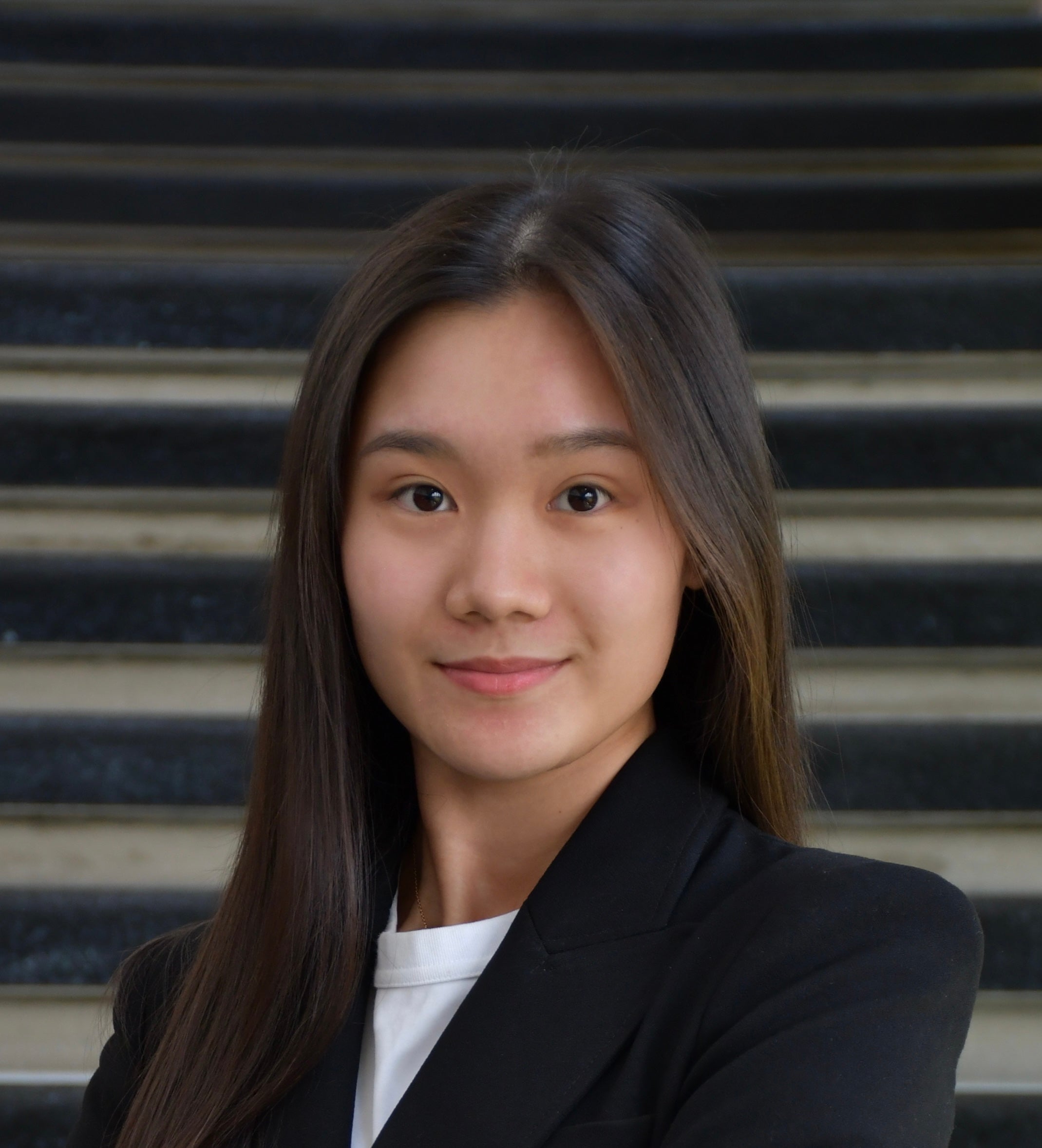 A student wearing a black jacket looks at the camera
