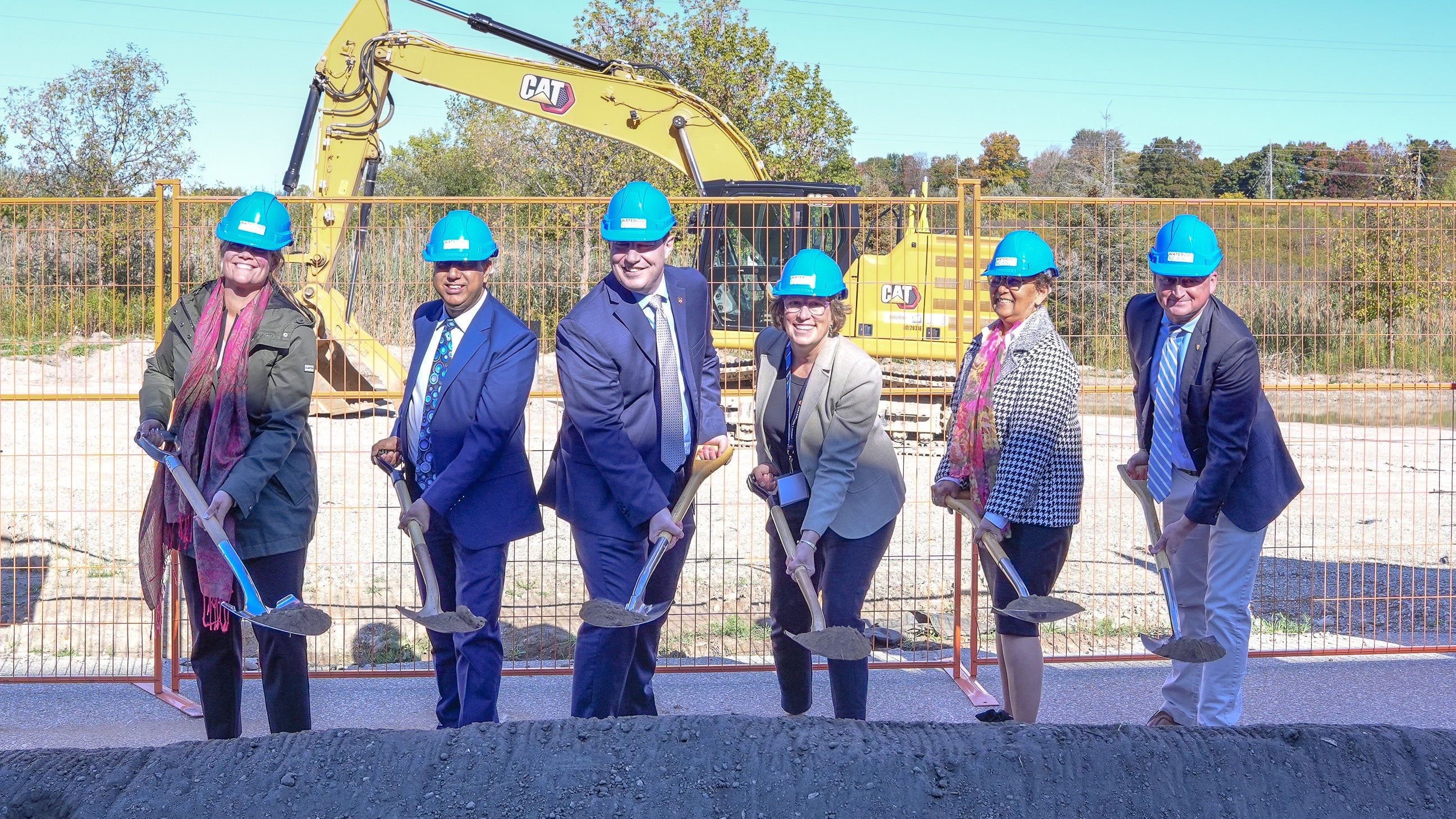 University and government leaders hold shovels at a groundbreaking event