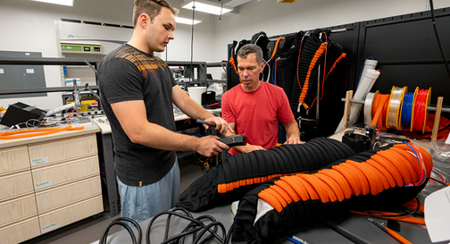 Two researchers in a lab working on compression boots