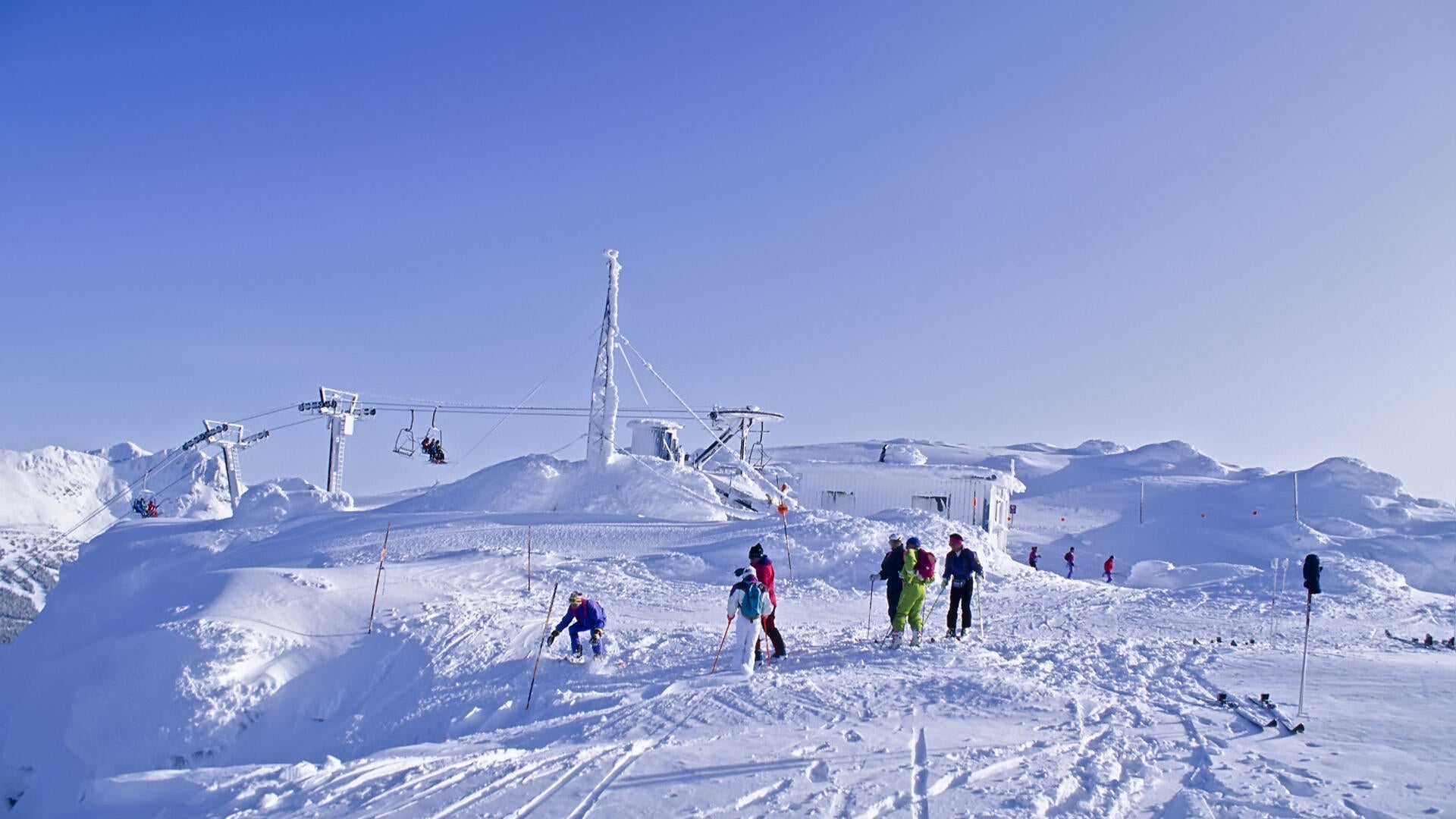 skiiers on top of a snowy hill