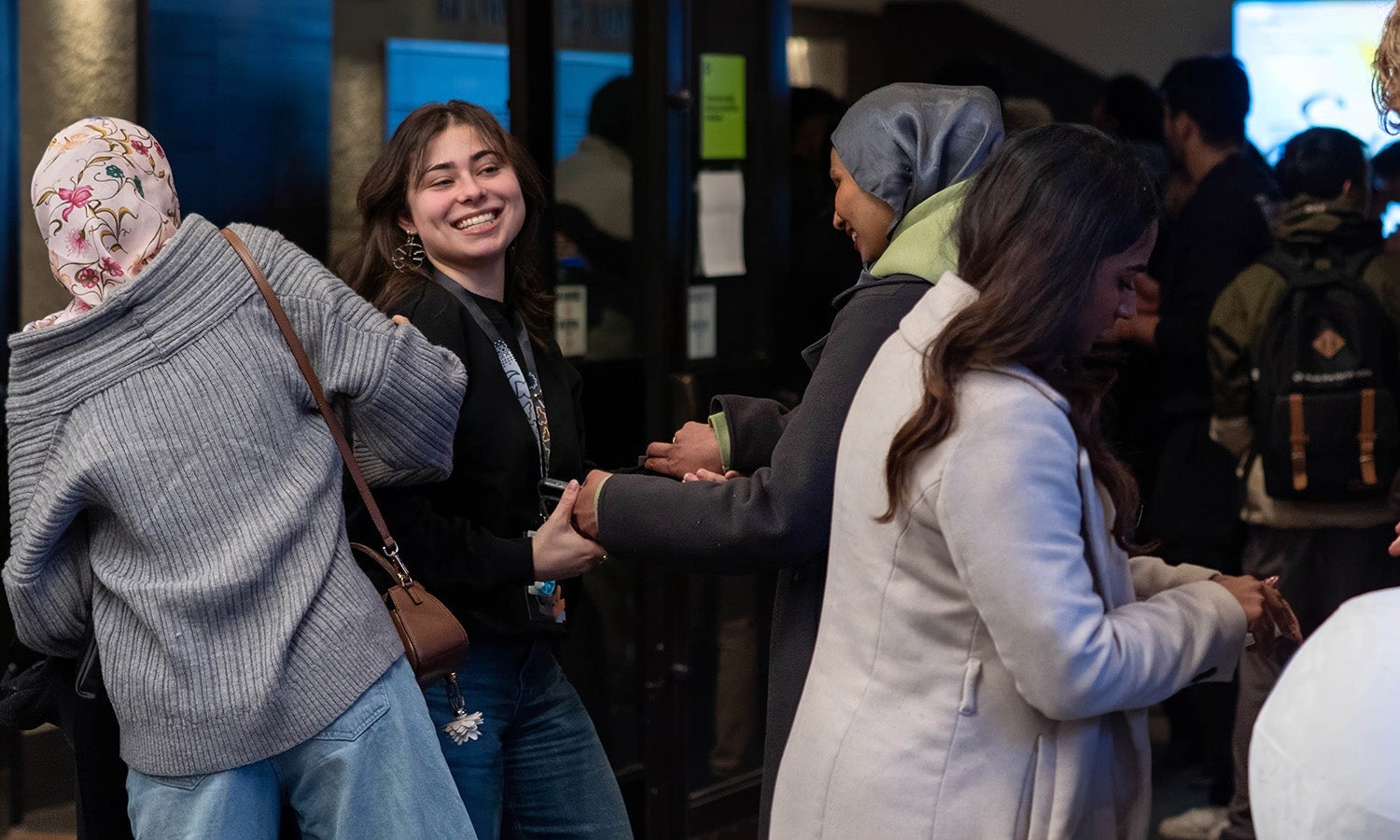 Nefise Akcakir greets friends in foyer at Symposium Day 1