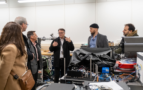 Thomas Jennewein explaining equipment in his lab to five other people