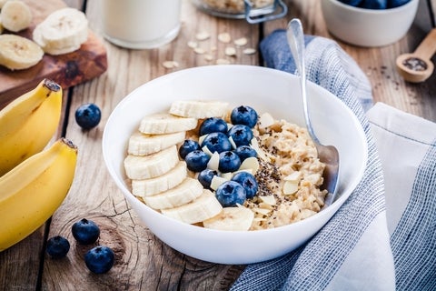 A bowl of oatmeal, bananas, blueberries, chia seeds and almonds
