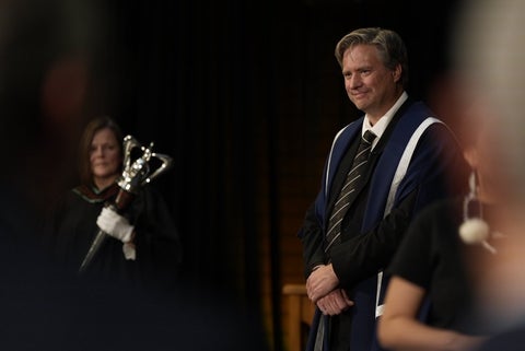 Dr. Rosehart stands in front of the University mace