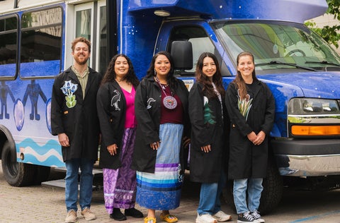 Five people standing in front of mobile lab.