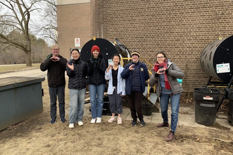 Chloe Sullivan and a group of students posing together in the environment