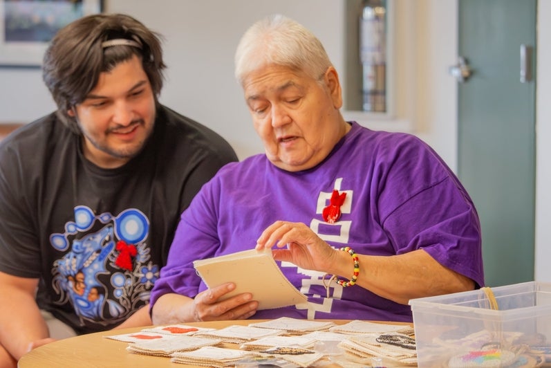 Rhea Green showing a student some of her beadwork designs