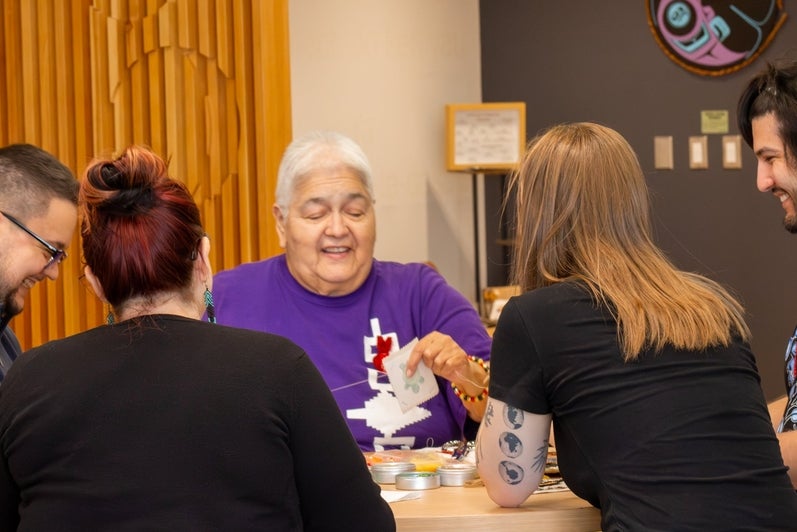 In the Visiting Aunties Program, Rhea Green connects with students and staff while they create their own beadwork 