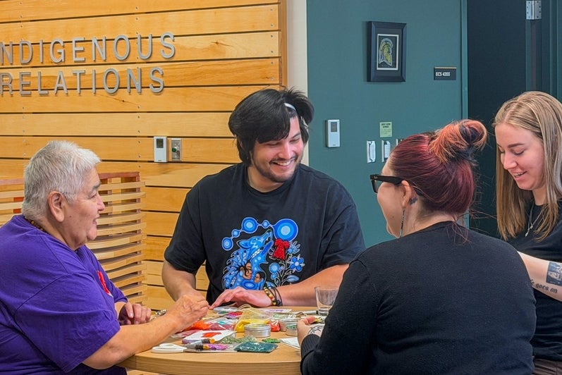 In the Visiting Aunties Program, Rhea Green connects with students and staff while they create their own beadwork 