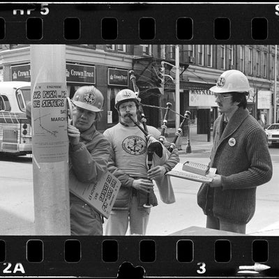 Black and white photo of people putting up signs