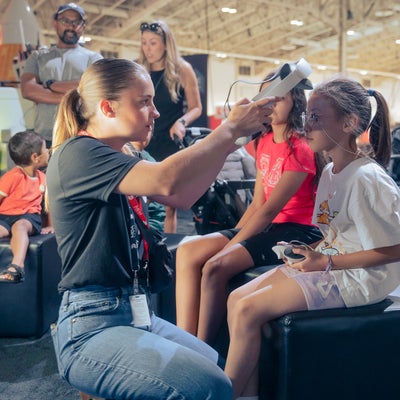 Mary McPhee helping kids through a virtual reality tour of the International Space Station