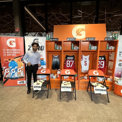 Luke Manimendre standing in business gear in the middle of a Gatorade products display