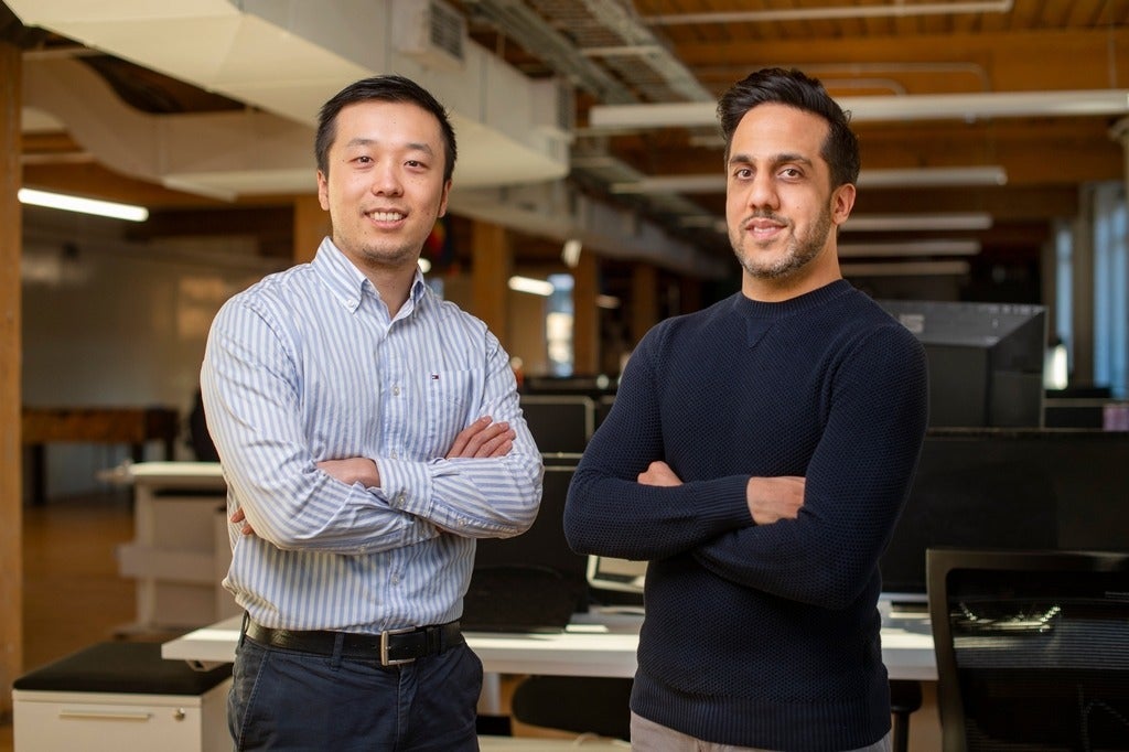 Huessin and Henry standing with arms crossed in their office