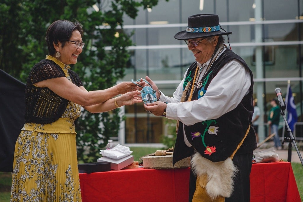Dean Lili Liu presents Elder Henry with a beaded medallion