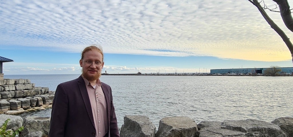 A man standing on the shore of a lake 