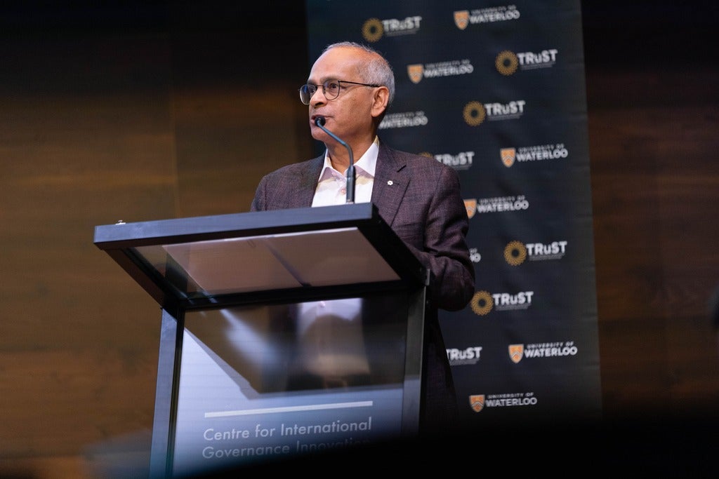 Vivek Goel address audience standing at podium on stage at the CIGI during Trust Speakers Series