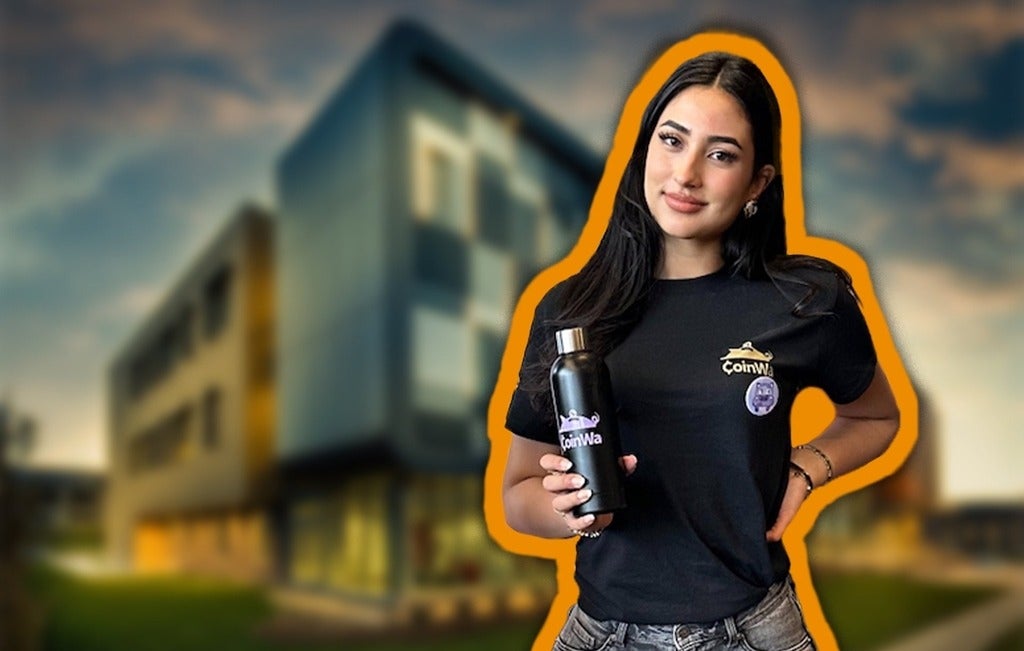 Naimah Venezia holding brabded water bottle against university building background