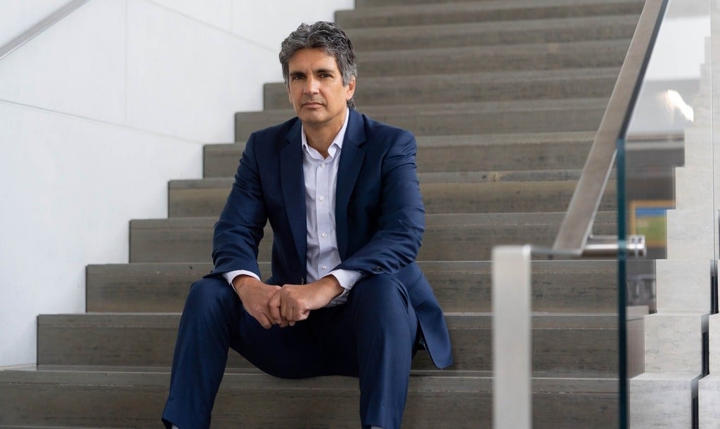 Joël Blit faces camera while seated on stairs.
