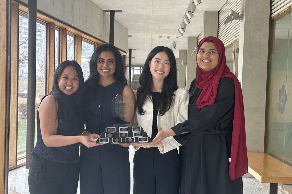 A group of people smiling and holding a trophy