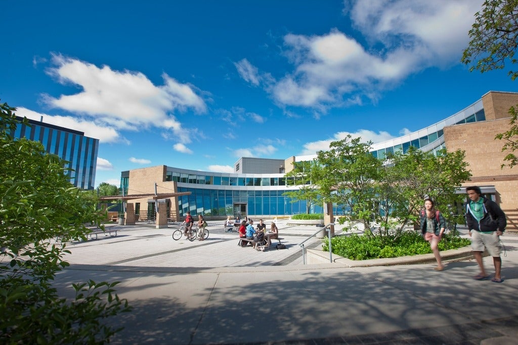 Students walk and sit outside the Student Life Centre