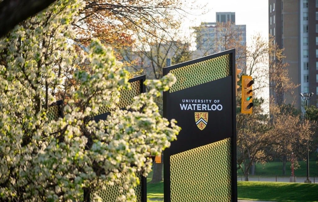 University of Waterloo signage behind spring flowers