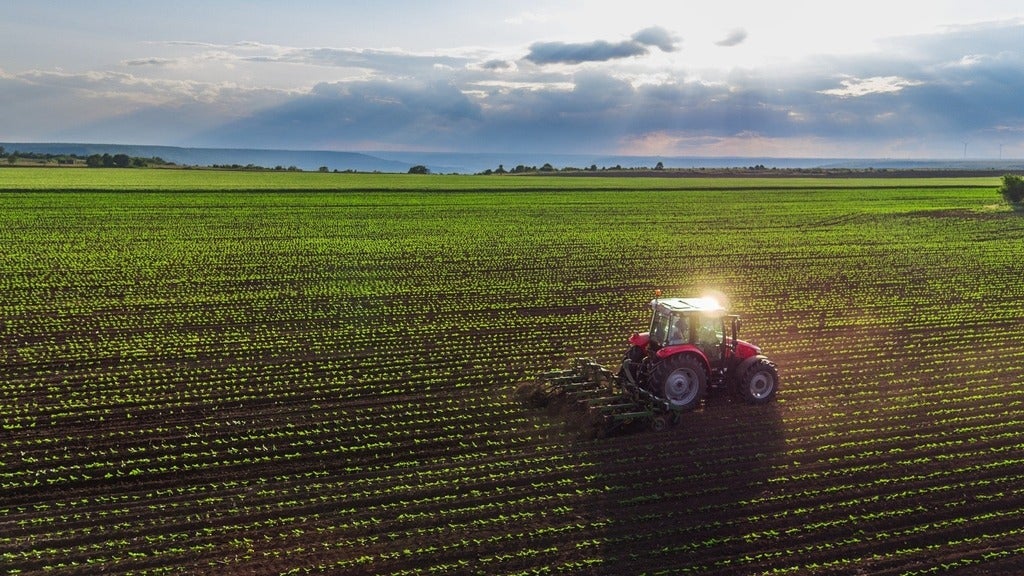 A tractor plows through a field