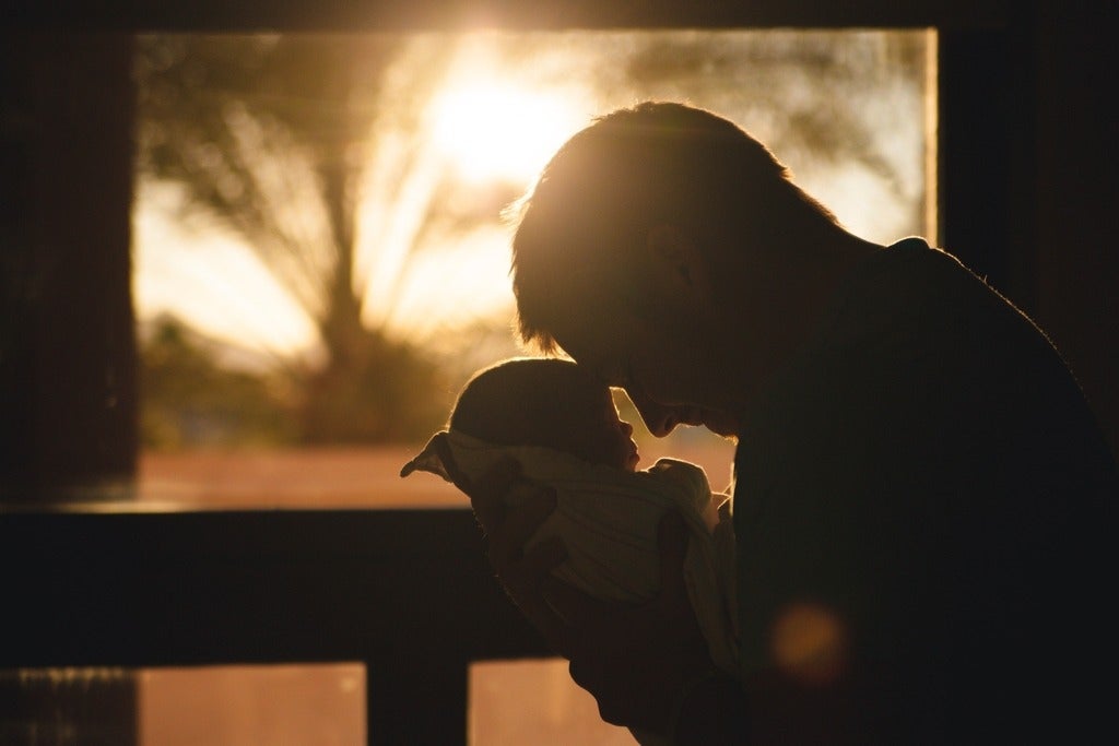 Man with baby at sunset