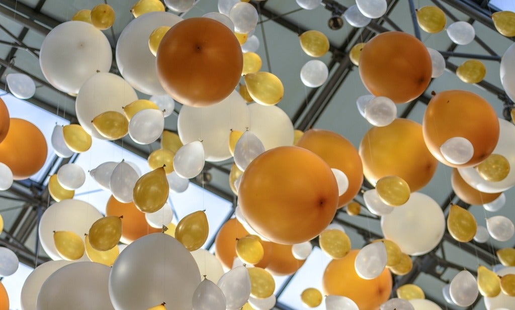 gold and white balloons float into the sky