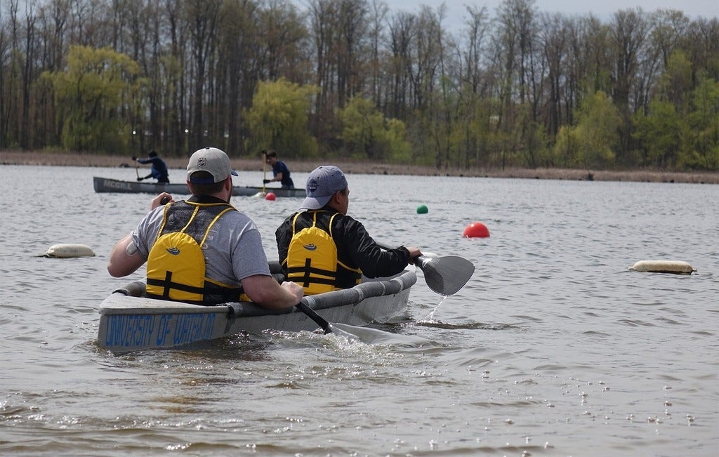Two students paddling in a concrete canoe