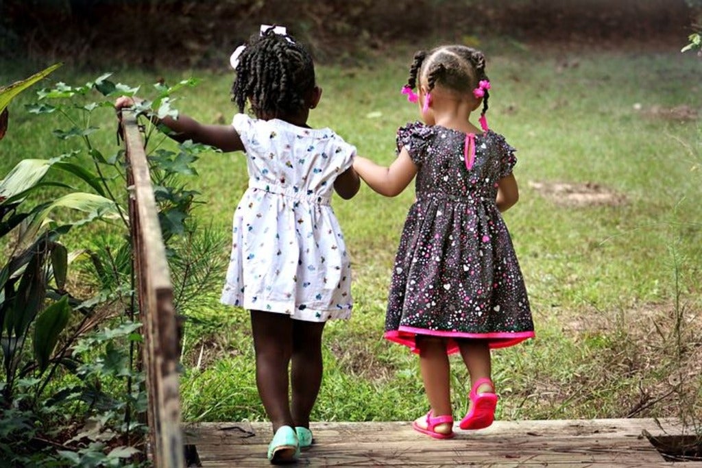 two little girls walking together in nature