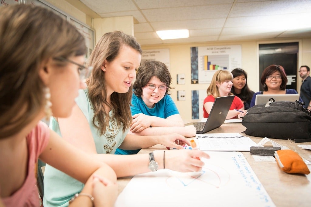Girls solving math problems in a classroom.