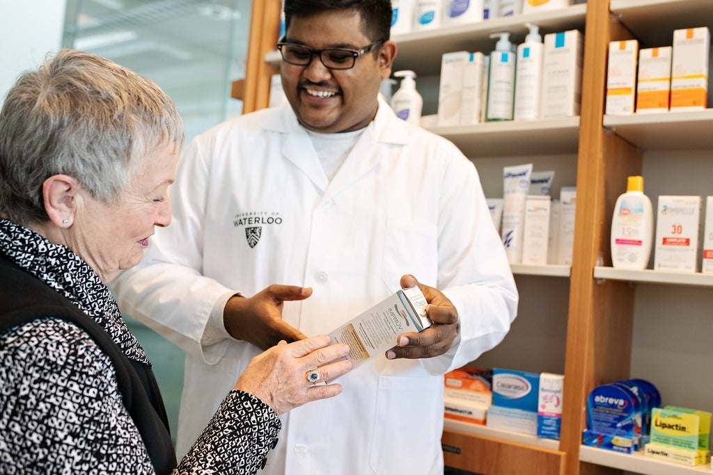 Waterloo pharmacy graduate assisting patient in a pharmacy