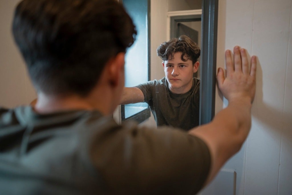 Male youth looking into mirror