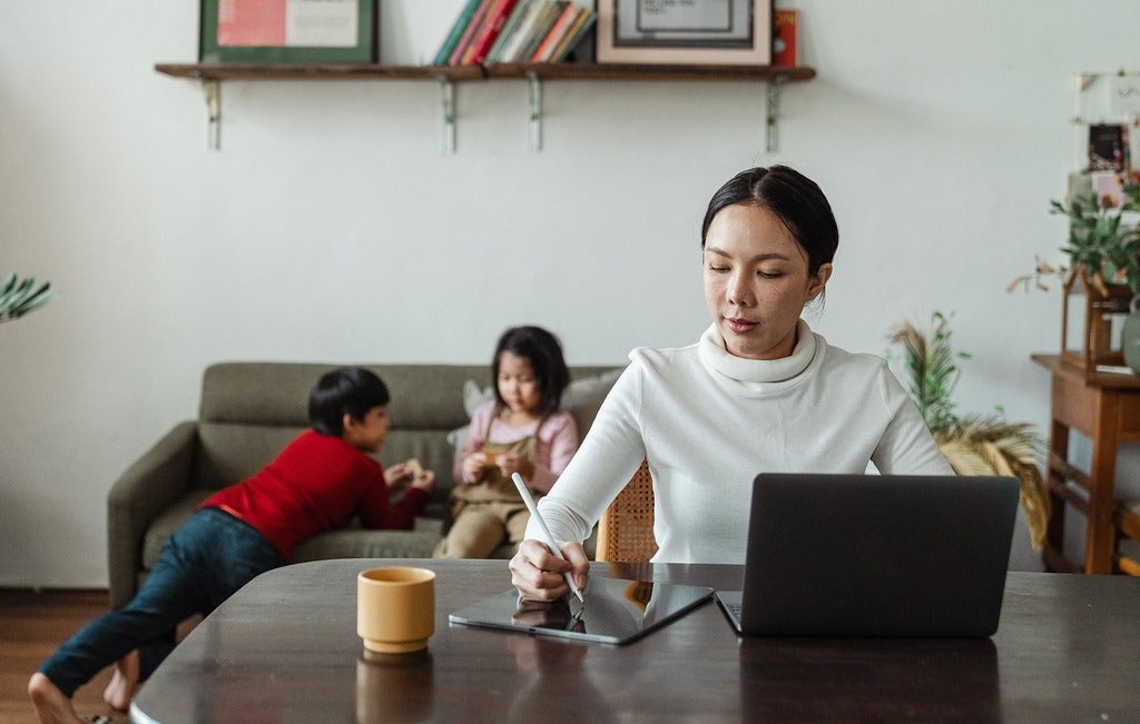 Women working from home with kids in the back 