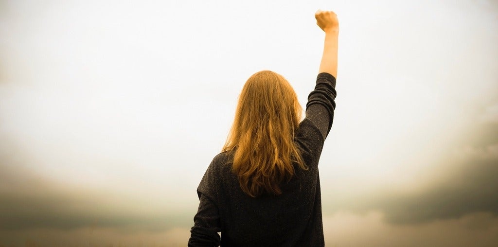 Rear view of woman with fist in the air