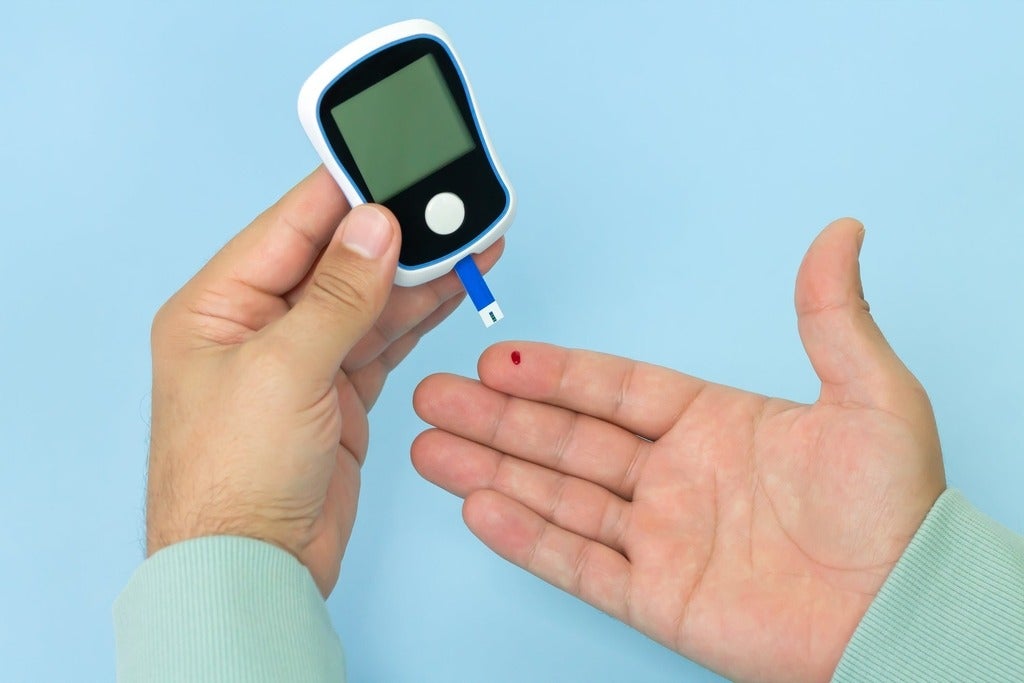 Man checking blood sugar level with glucometer.