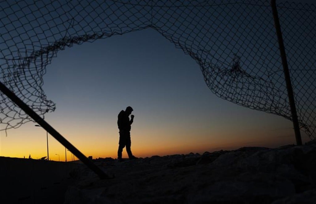 the silhouette of a man surrounded by a fence