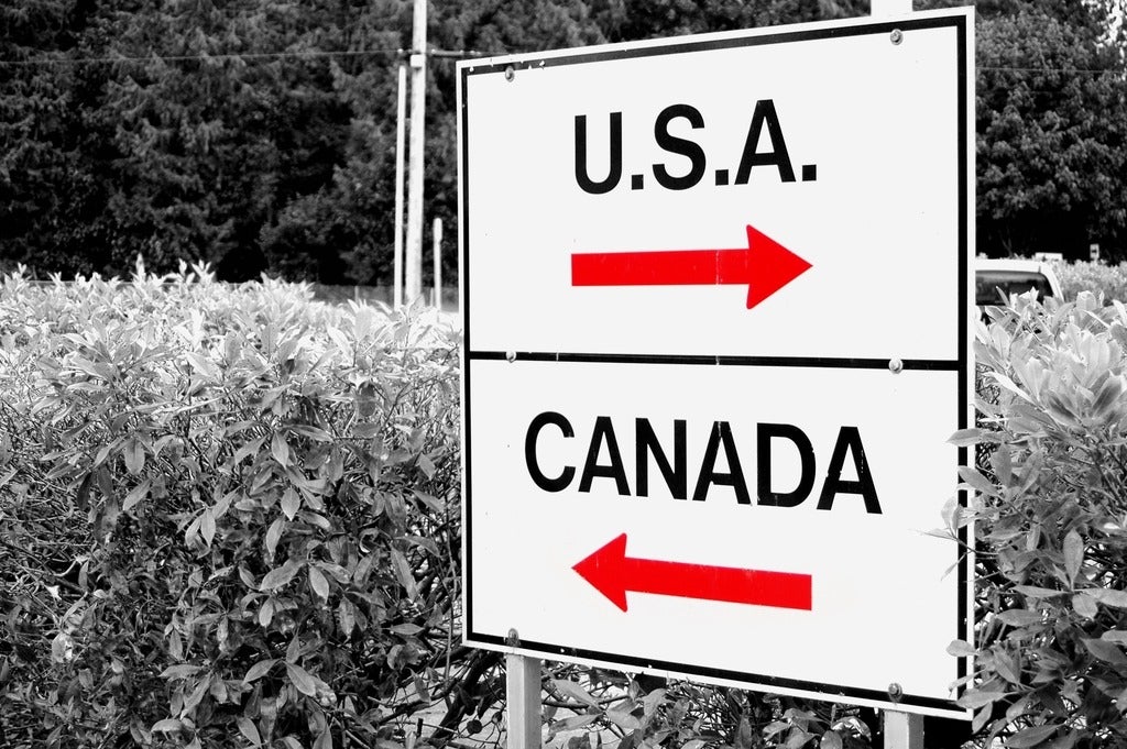 Direction signs on post featuring arrow and the words "U.S.A" and "Canada"