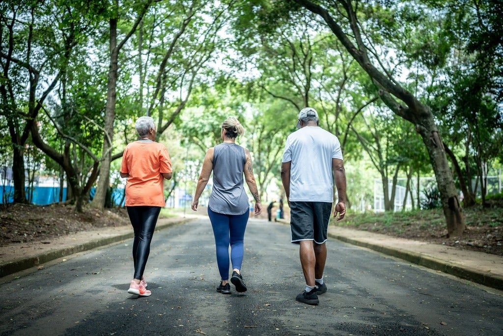 Three people walking in a public park. 