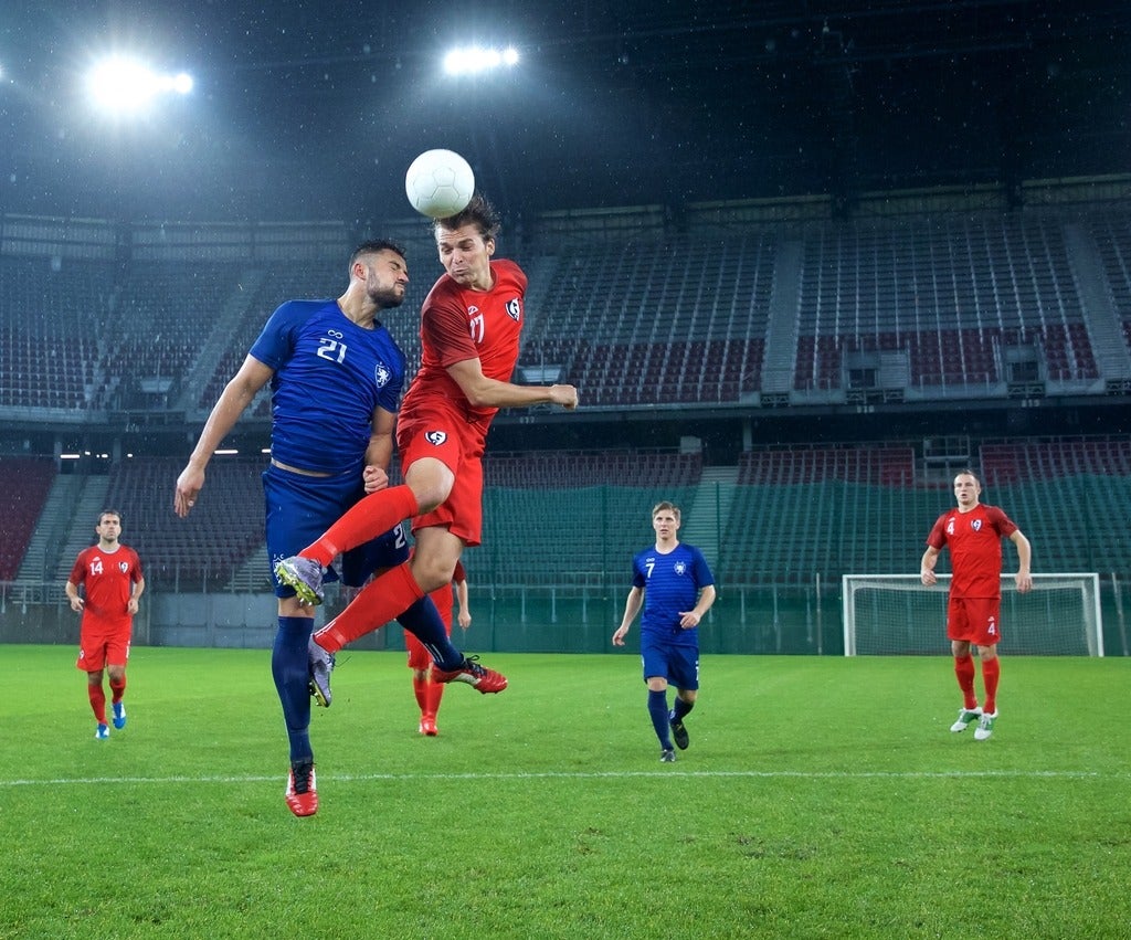 Soccer player jumping and heading the ball.