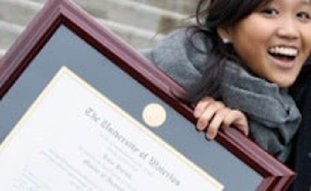 A young woman holds her framed Waterloo degree.