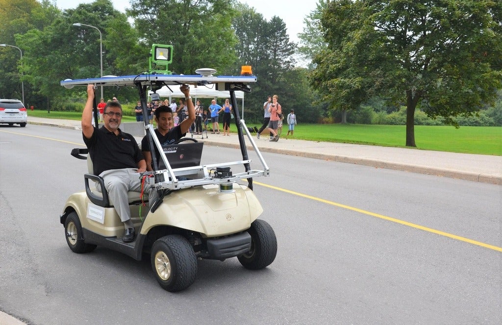 Feridun Hamdullahpur and Alex Rodrigues in a self-driving golf cart during testing in 2015 at the University of Waterloo.