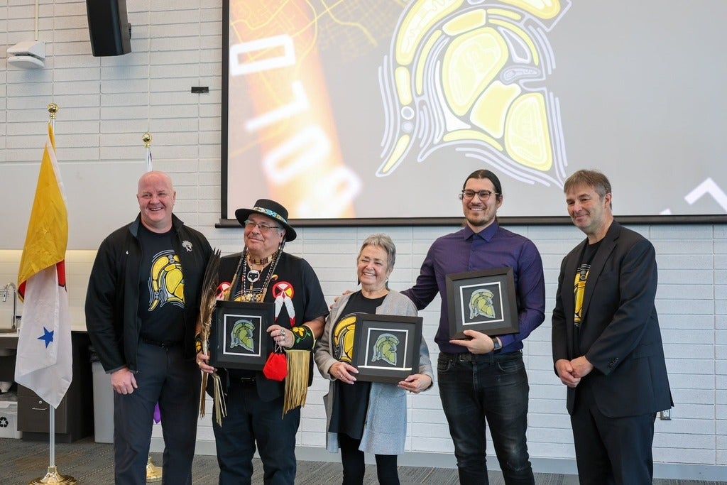 Staff from Waterloo Athletics and Recreation and Office of Indigenous Relations holding frames with the Warriors Indigenous logo