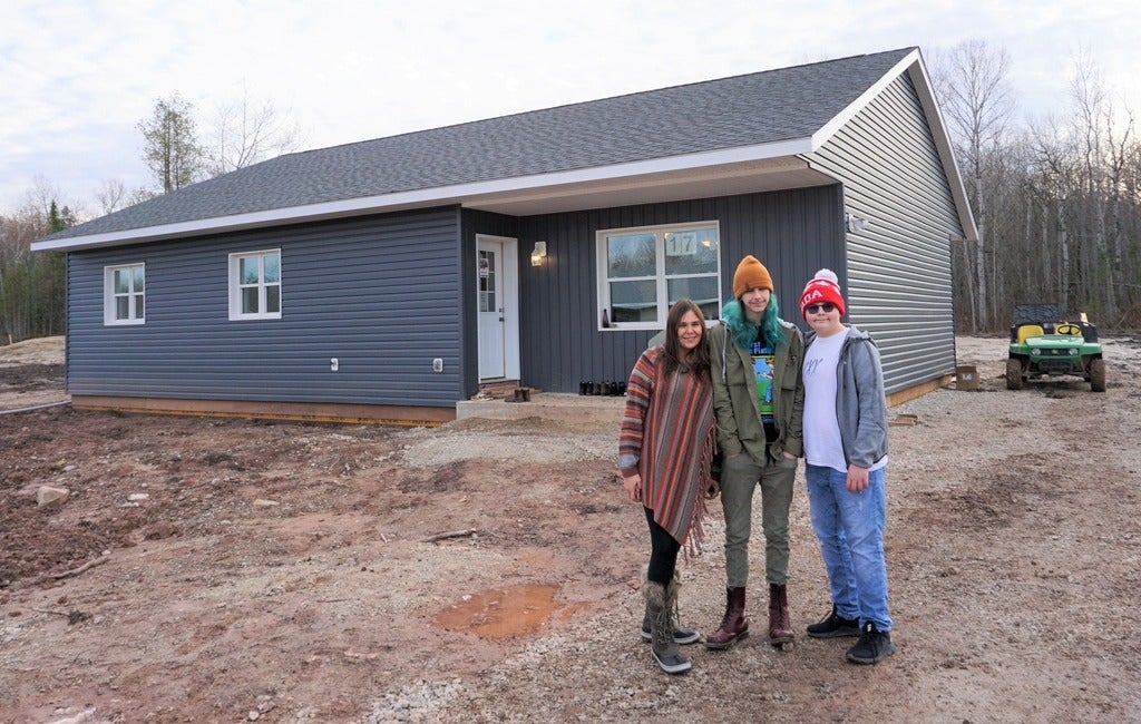 Melissa Millette (left to right) with two of her children, Riley and Reichal, pose outside their new house.