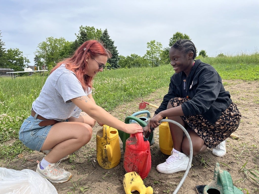 High school student watering plants in garden