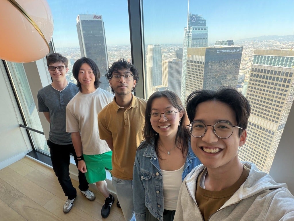 Atoms co-op students pose for photo at the Atoms office with cityscape in the overshoot