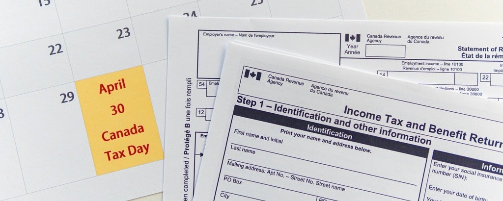 Tax filing papers beside a calendar 