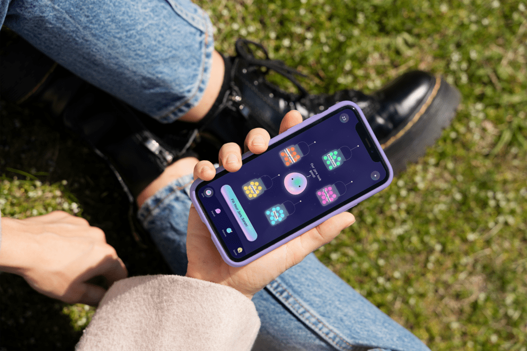 Someone sitting looks at apps on a phone screen 