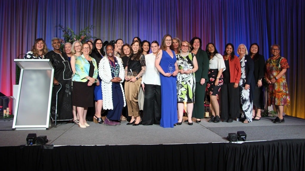 Award winners standing on stage with their awards