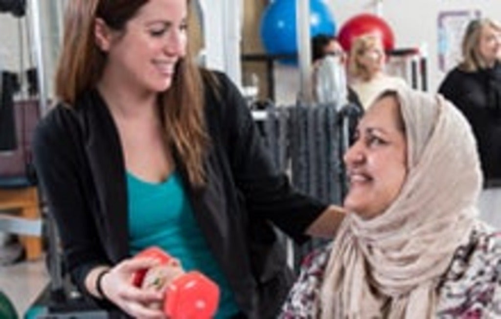 Erin Rellinger-Smith assists a recovering breast cancer patient with workout